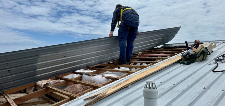 Man,wearing,a,harness,standing,on,the,wooden,battens,of